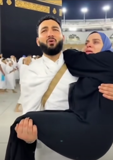 رجل يحمل زوجته باكيًا خلال طوافه عند الكعبة